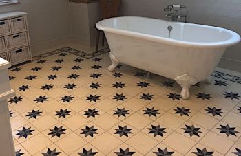 Badezimmer mit antiker Badewanne und Zementfliesen mit Sternen auf dem Boden